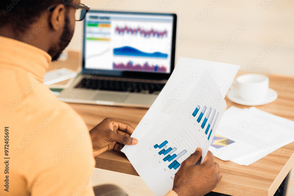 Poster Busy Day. Rear view of afro trader working with charts and market reports on computer screen in office, free space