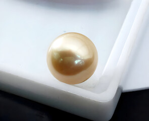 A Single Golden Pearl. Perfect-Round and Smooth, Lustrous Surface on a white box