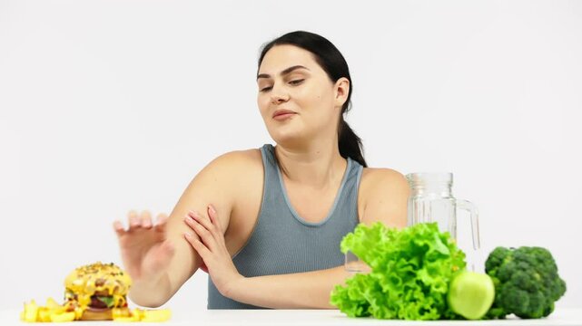 Full-figured woman on a light background choosing healthy food over less nutritious options. Perfect for promoting conscious decisions for a healthier and balanced diet