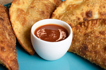 Fried pastries with tomato sauce, ketchup, on a blue plate, delicious