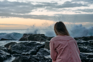 Fototapeta premium Beautiful woman is enjoying the sunset over the rocky beach, tropical island, ocean bay