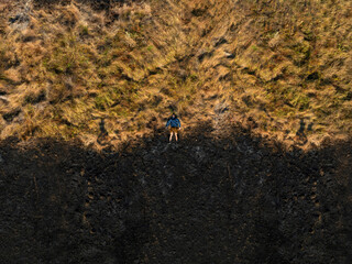 A single man laying in a field burned by wildfire