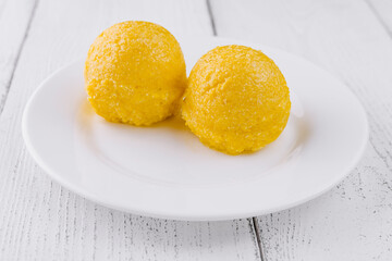 Two scoops of yellow polenta - Romanian traditional food serving on a white plate