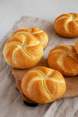Homemade Kaiser Rolls on a wooden board, side view.