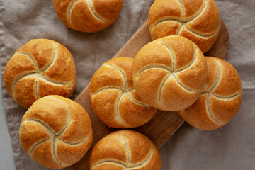 Homemade Kaiser Rolls on a wooden board, top view.