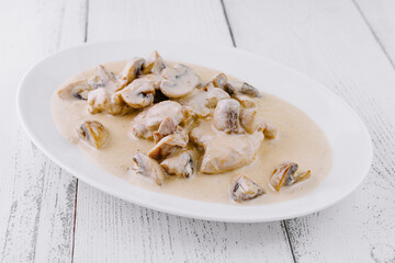 Sliced chicken breast with creamy mushroom sauce on white plate
