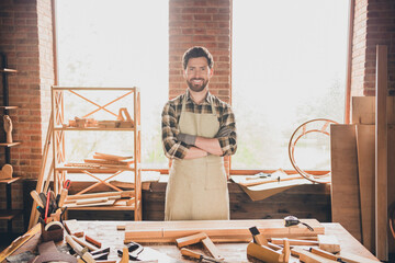 Portrait photo of confident man wearing checkered shirt and apron folded hands with his desk...