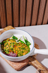 Delicious salmon patties with green herbs and white sauce served on white plate