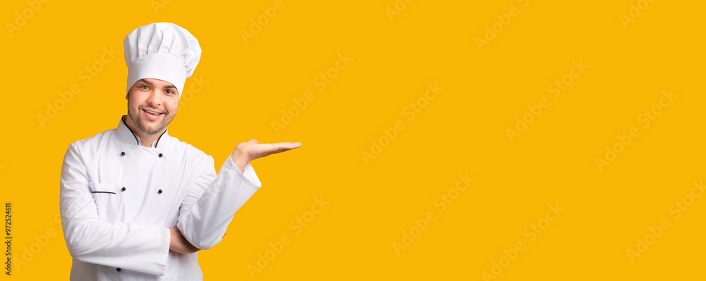 Poster smiling chef man holding invisible object on open hand palm standing over yellow studio background. 