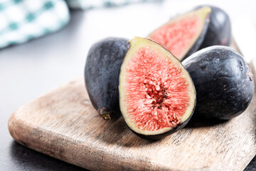 Fresh figs on cutting board on black stone