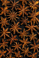 Anise stars background food pattern, top view close up photography fragrant spices dry anise seeds on black background, natural organic seasoning texture, dark colored minimal flat lay