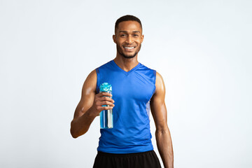 Portrait Of Athletic Black Man Holding Bottle Of Refreshing Water, Resting After Workout, Thirsty Male With A Drink