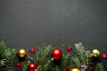 Christmas flat lay background with fir tree and holiday decorations on black.