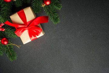 Christmas present with holiday decorations on black with copy space. Black Christmas flat lay background for your design.