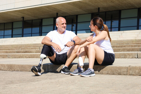 Father with prosthetic leg and daughter sitting on steps
