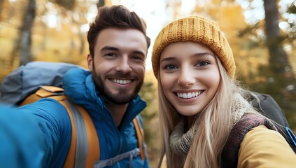 Fototapeta premium Happy couple hiking in the woods, smiling and taking a selfie.