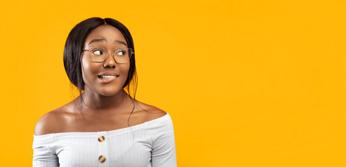 Oops. Millennial Afro Girl Biting Lips Looking Aside Standing Over Orange Studio Background....