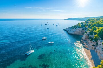 Scenic Beach Cove with Sailboats on Clear Blue Water and Green Hills in the Background