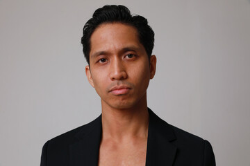 Portrait of thoughtful young asian man posing over white background. 