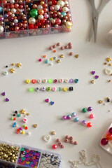 Making friendship bracelets with letter beads. Jewelry making supplies on the table. Selective focus.