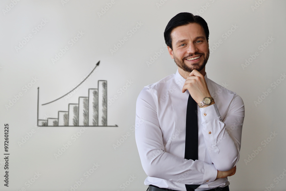 Poster a man in a suit is smiling and looking at the camera. he is wearing a watch and a tie. the backgroun