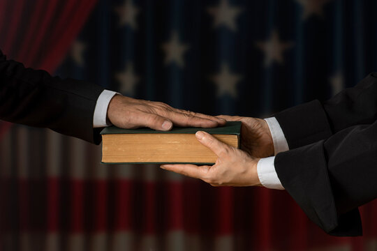 Hand on the Bible in court or the oath on the constitution book during the inauguration in parliament. Oath of Office. - Powered by Adobe