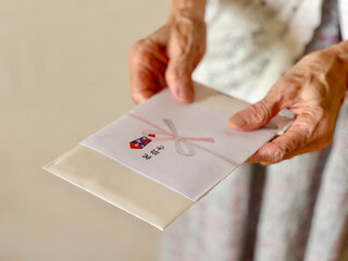 祝敬老の祝儀袋を持つ高齢女性の手