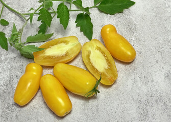 Tomatoes, yellow tomatoes, elongated, for salads, for healthy eating, with green leaves, top view.