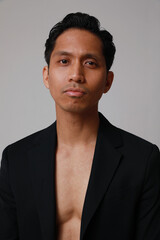 Obraz premium Vertical portrait of young asian man posing over white background. Vertical.