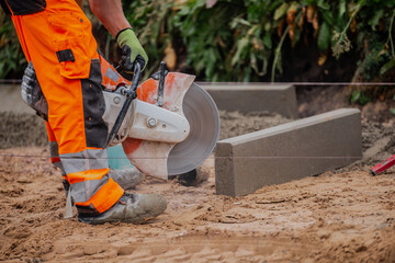 Asphalt power tool cutter working on pavement cutter, Worker wearing safety outfit
