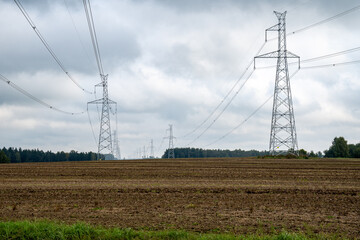 Power mast for high voltage electricity with cables in landscape.