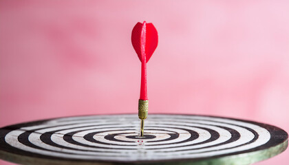 Arrow at darts target, pastel pink backdrop. Business and achieving goals concept.