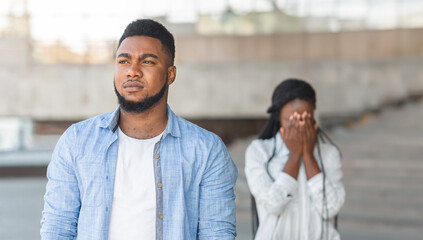 Broke up relationship. Depressed african american girl crying on background, her boyfriend leaving...