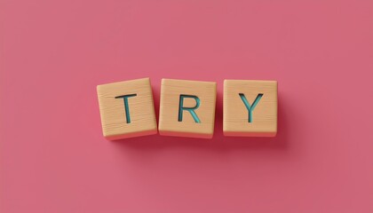 Inspiring wooden blocks spelling the word 'TRY' on a vibrant pink background, encouraging positivity and motivation.