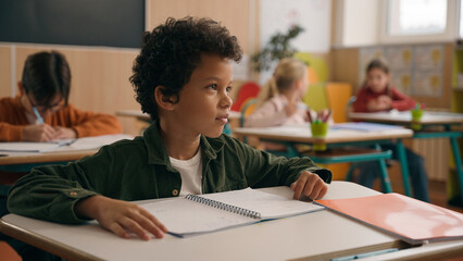 African American school boy son child guy little kid schoolboy pupil student study learn elementary education studying learning class lesson answer teacher question talk nod head yes talking agree