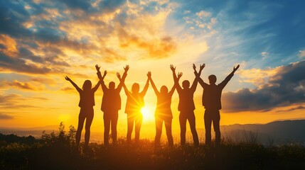 Fototapeta premium Silhouetted group of friends with arms raised, celebrating sunset on a hilltop