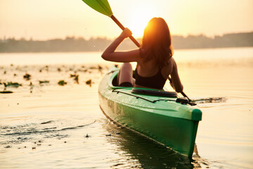 Rear side view. Young woman is with the sup board on the lake
