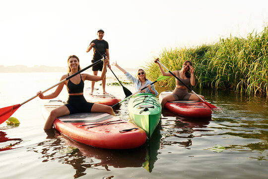 Women and man. Friends are together on sup boards on the lake