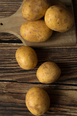 young raw potato. on a dark wooden background. food