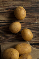young raw potato. on a dark wooden background. food