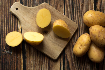 young raw potato. on a dark wooden background. food