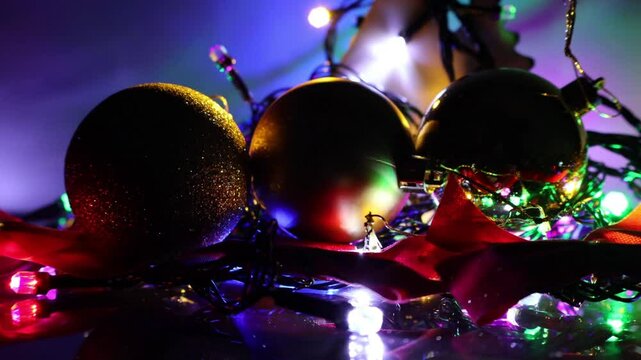Una toma de cerca de bolas de navidad rodeada con luces de colores. Decoraci&oacute;n de navidad y fin de a&ntilde;o