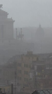 le cupole di Roma e l'Altare della Patria sotto una fitta pioggia battente.
La citt&agrave; in una giornata grigia e invernale sotto la piaggia. 