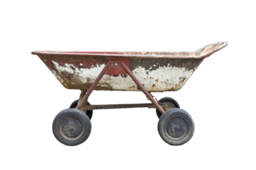 Weathered wheelbarrow resting on a garden path under soft morning light in a tranquil setting