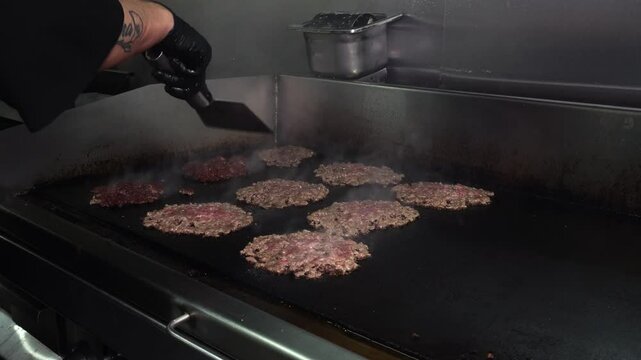 cheff preparing hamburgers in the grill