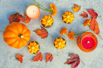 Pumpkin cupcakes, autumn leaves, orange candles and pumpkins on a light background. autumn holidays halloween and thanksgiving.  top view. 