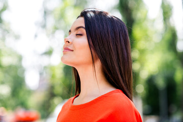 Photo of pretty teen good mood girl closed eyes enjoy sunny weather wear red clothes walk outside urban city park