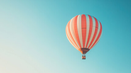 Naklejka premium A hot air balloon floating against a clear blue sky, representing freedom and adventure.
