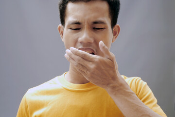 Asian men have bad breath caused by swollen gums, stomach problems and cavities.