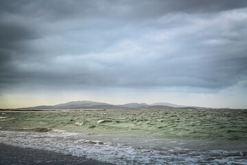 A summer, cloudy HDR image of West Kilbride beach on South Uist with the island of Barra in the...